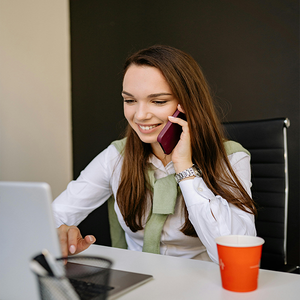 HR recruiter talking on the phone while reviewing candidate profiles on a laptop during recruitment and hiring process in Canada